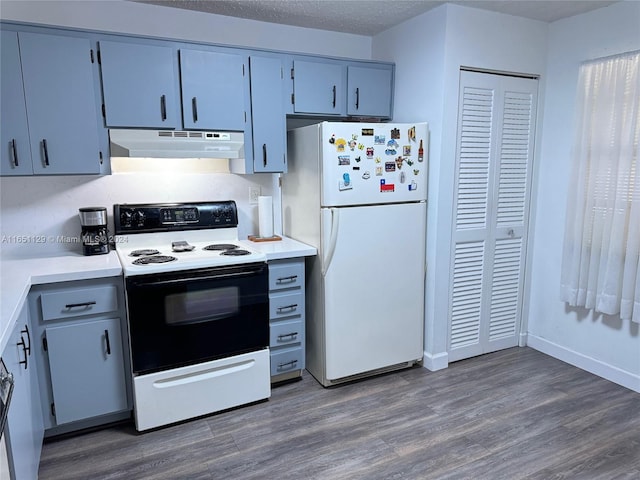 kitchen featuring dark wood-type flooring, white appliances, and a textured ceiling