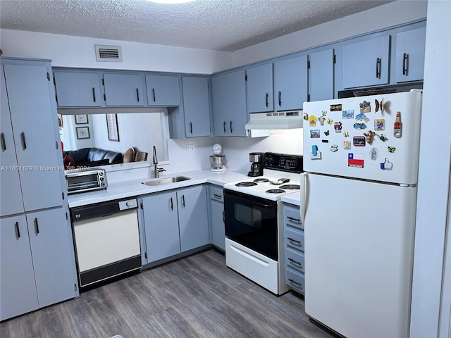 kitchen with white appliances, dark hardwood / wood-style flooring, sink, and a textured ceiling