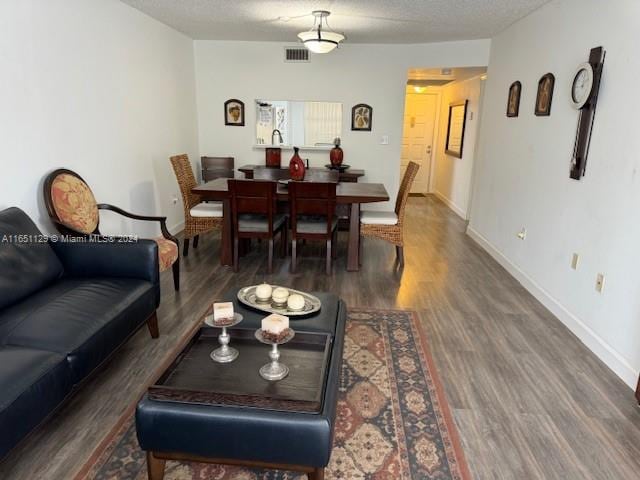 living room with dark hardwood / wood-style flooring and a textured ceiling