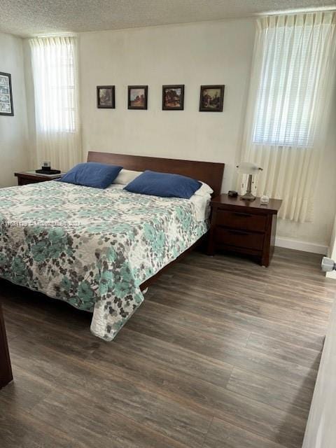 bedroom with a textured ceiling and wood-type flooring