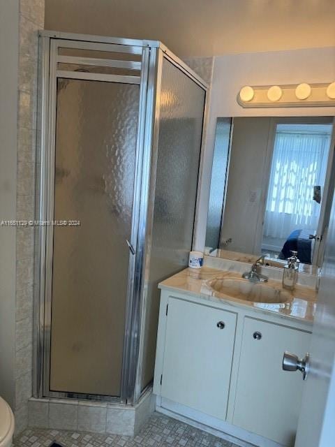 bathroom with a shower with door, vanity, and toilet