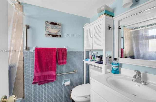 bathroom with a shower with curtain, vanity, toilet, and tile walls