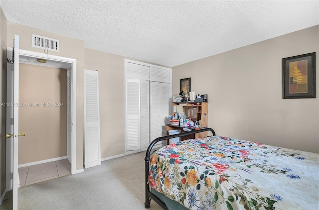 bedroom featuring light carpet and a textured ceiling