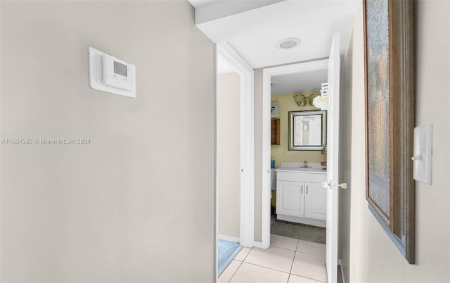 hall with sink and light tile patterned flooring