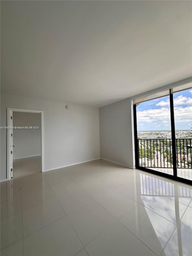 5252 NW 85th Ave Unit 1909, Doral, FL 33166 - empty room with baseboards, light tile patterned flooring, and a wall of windows