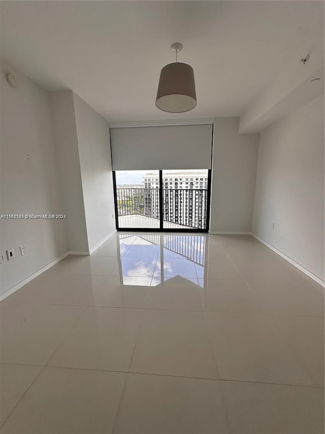 empty room featuring expansive windows and light tile patterned flooring