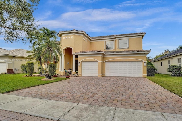 mediterranean / spanish-style house featuring a garage and a front yard