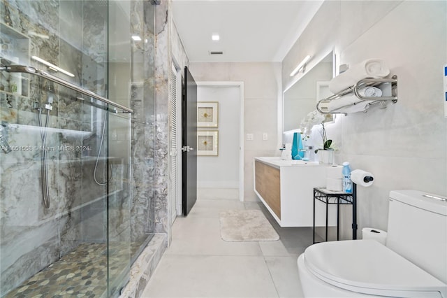 bathroom featuring tile patterned flooring, vanity, toilet, and a shower with shower door