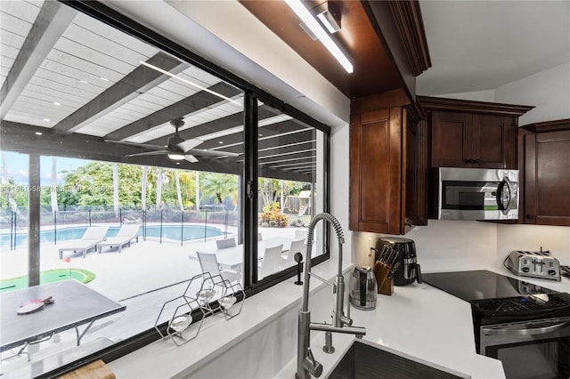 kitchen with a wealth of natural light, stainless steel appliances, sink, and ceiling fan