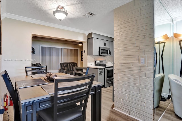 dining space featuring wood-type flooring, crown molding, and a textured ceiling