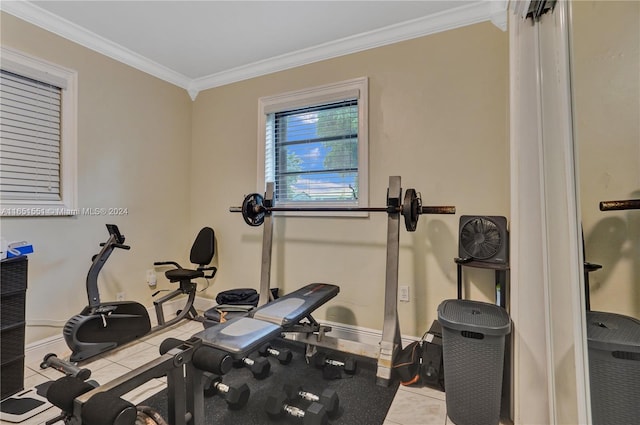 exercise room featuring ornamental molding and light tile patterned flooring