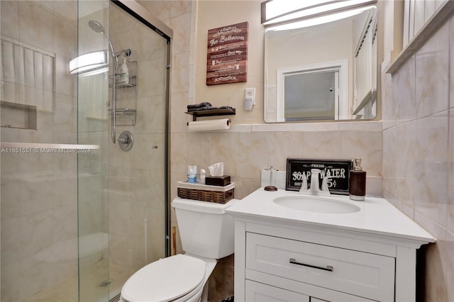 bathroom with vanity, toilet, decorative backsplash, and a shower with shower door