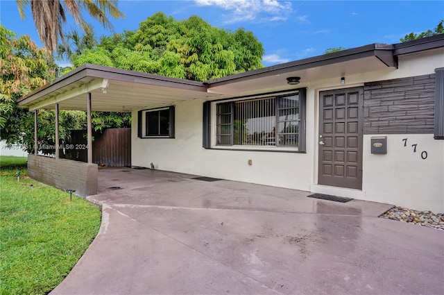 view of front of property with a front yard and a carport