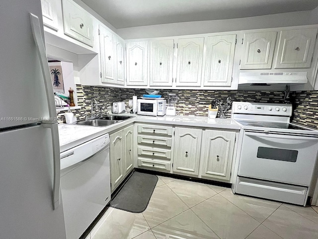 kitchen featuring white appliances, backsplash, light tile patterned floors, sink, and white cabinets