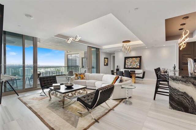 living room with expansive windows and a raised ceiling