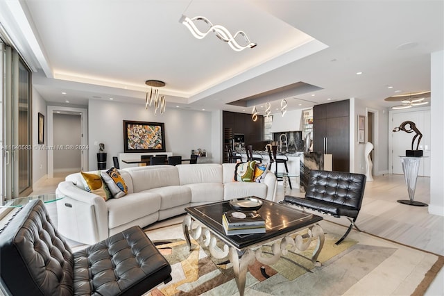 living room featuring recessed lighting and a raised ceiling