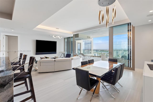 dining space with recessed lighting, a raised ceiling, and baseboards