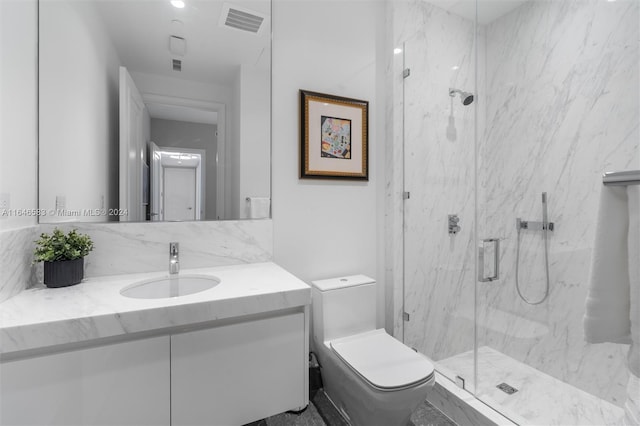 bathroom with vanity, toilet, visible vents, and a marble finish shower