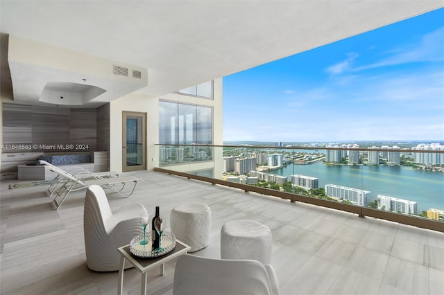 balcony featuring visible vents and a water view