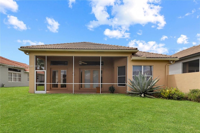 back of house with a lawn and a sunroom