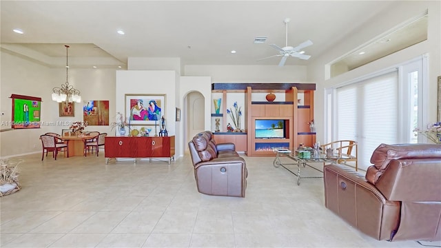 living room with ceiling fan with notable chandelier and light tile patterned flooring