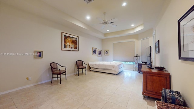 bedroom featuring ceiling fan, light tile patterned floors, and a tray ceiling