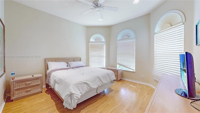 bedroom with light wood-type flooring, lofted ceiling, and ceiling fan