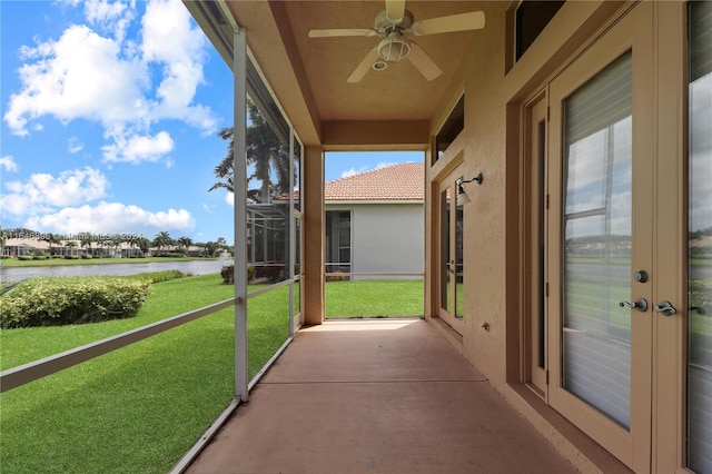 unfurnished sunroom with a water view and ceiling fan