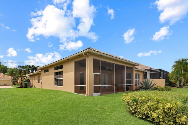 rear view of property with a yard, central AC unit, and a sunroom