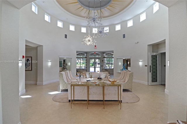 dining area featuring a chandelier, a raised ceiling, and a towering ceiling