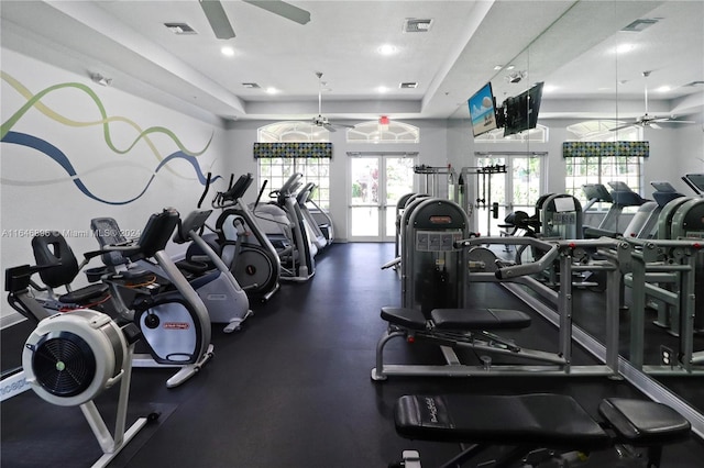 gym featuring a tray ceiling, french doors, and ceiling fan