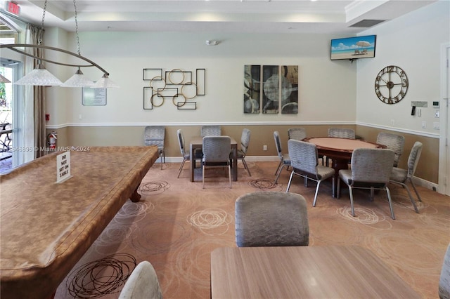 dining space with a tray ceiling and crown molding