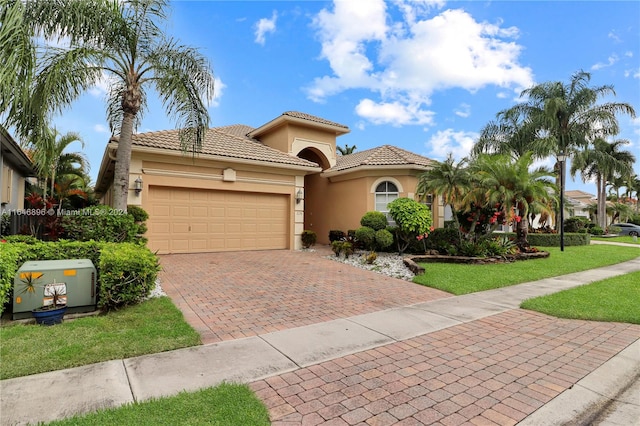 mediterranean / spanish-style house with a garage and a front lawn