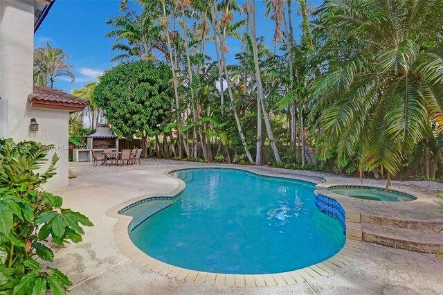 view of pool with an in ground hot tub and a patio area