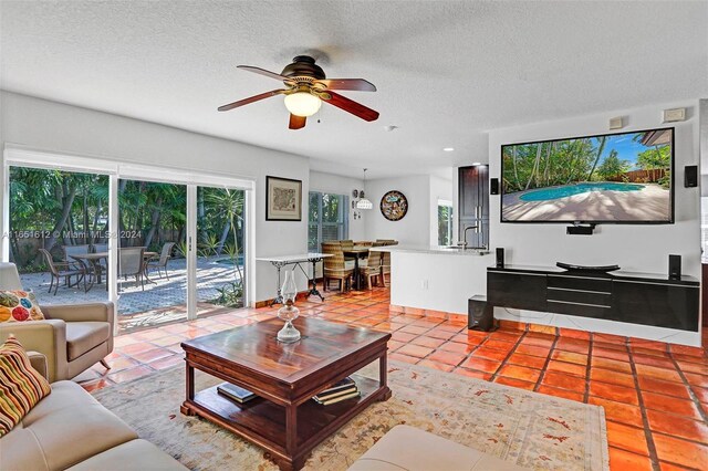 tiled living room featuring a textured ceiling and ceiling fan