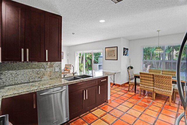 kitchen with hanging light fixtures, decorative backsplash, light stone counters, dishwasher, and sink