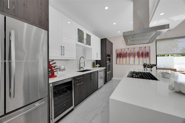 kitchen featuring white cabinets, stainless steel appliances, sink, beverage cooler, and island range hood