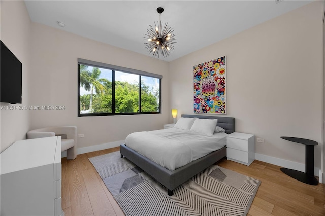 bedroom with wood-type flooring and a notable chandelier