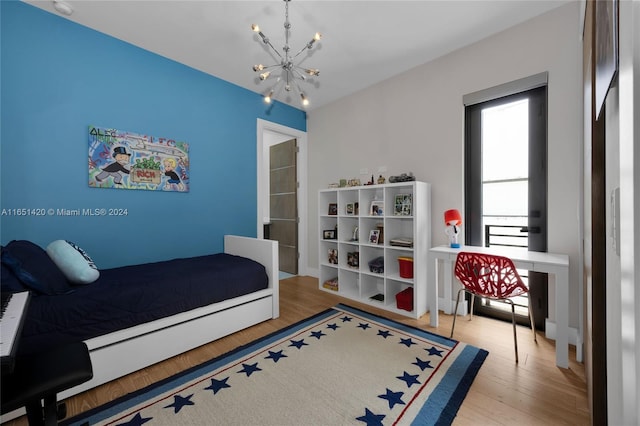 bedroom with a chandelier and light hardwood / wood-style floors