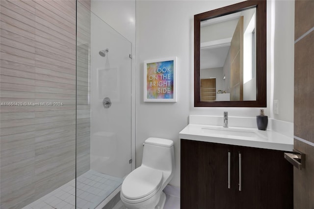 bathroom featuring tiled shower, toilet, and vanity