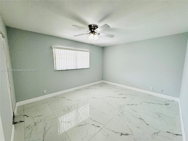 empty room with a textured ceiling and ceiling fan