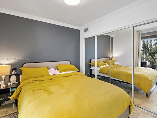 tiled bedroom featuring ornamental molding and a closet