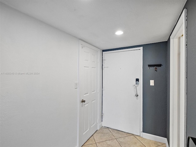 doorway to outside with light tile patterned flooring