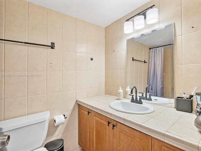 bathroom featuring tile walls, toilet, and vanity