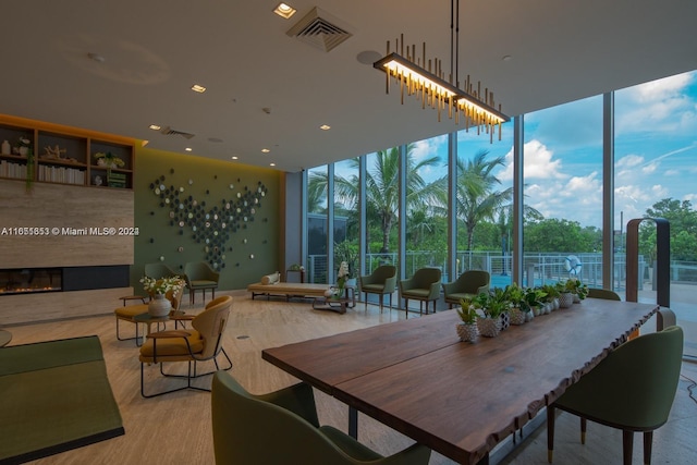 dining area featuring light wood-type flooring and floor to ceiling windows