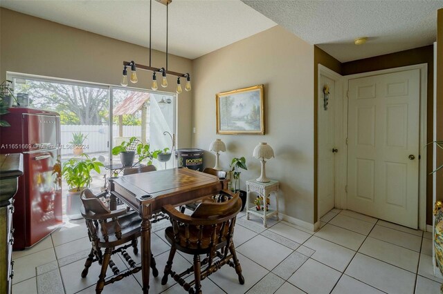 dining room featuring a textured ceiling and light tile patterned flooring