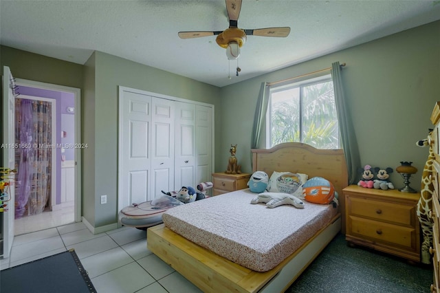 tiled bedroom featuring a textured ceiling, ceiling fan, and a closet