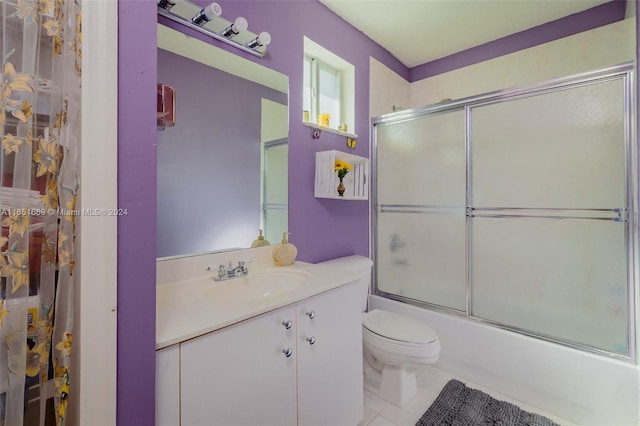 full bathroom with shower / bath combination with glass door, tile patterned flooring, toilet, and vanity