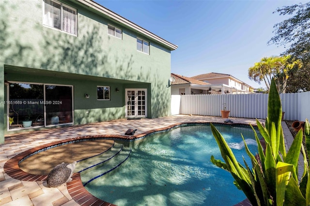 view of swimming pool featuring a patio area and french doors