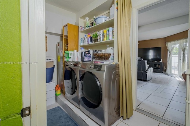 laundry room with washer and clothes dryer and light tile patterned floors